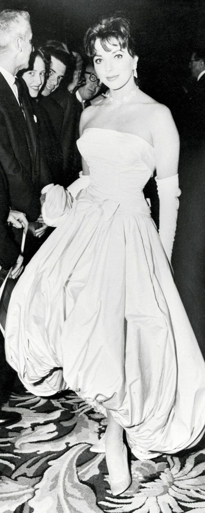 Joan Collins clearly turned heads in this bubble hem gown—and in the '50s no formal look was complete without elbow-length gloves.