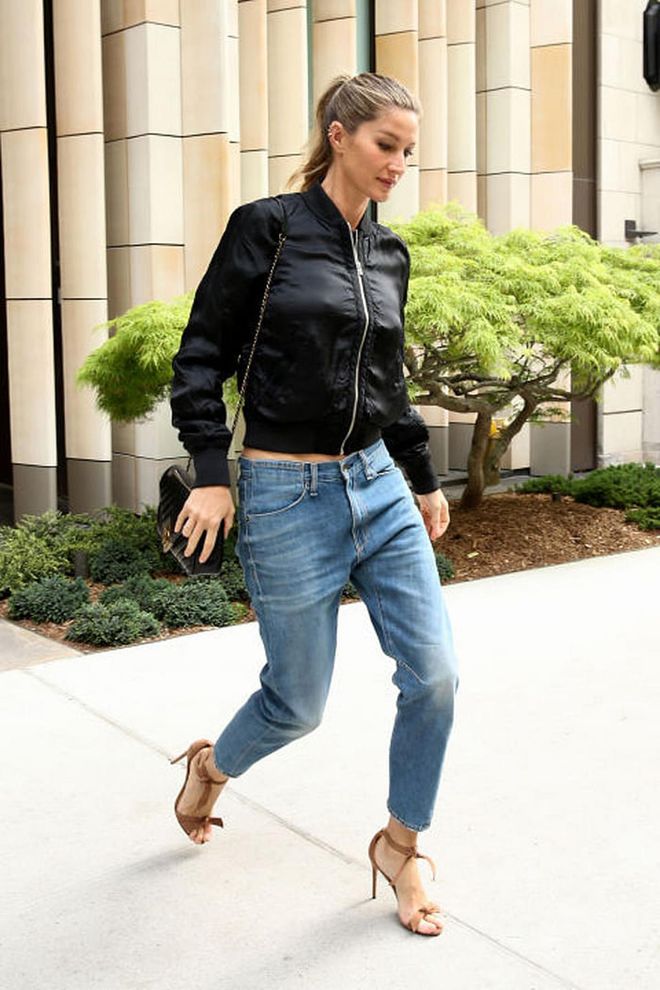 Keep your look cool by pairing a slouchy pair of boyfriend jeans with a black bomber jacket and strappy heels à la Gisele. Photo: Splash