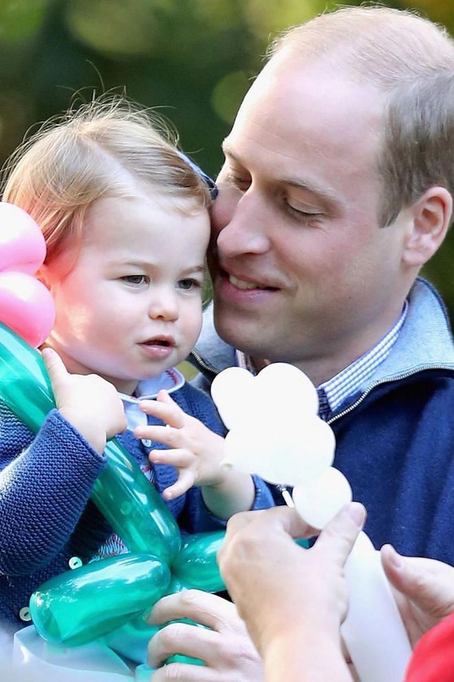 William holds onto Princess Charlotte as she plays with her balloon creations at a children's party during the royal visit to Canada.

Photo: Getty