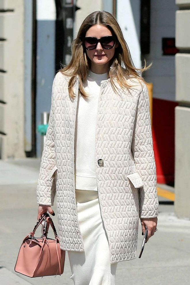 Olivia Palermo is elegant in white on white for a minimalist approach to the skirt and top story. A pink bag lends interest. Photo: Splash