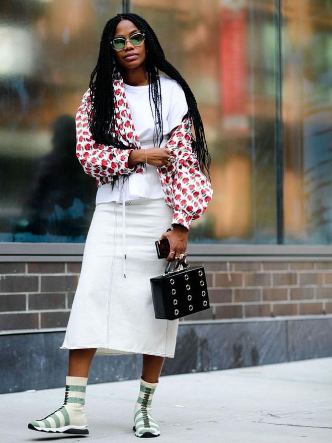 Put a sporty twist on a feminine look by pairing sock sneakers with a midi-length skirt and ladylike bag.