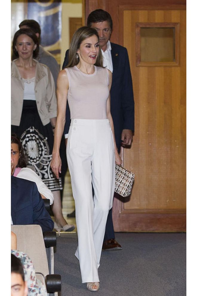 She's frequently seen in light, streamlined neutrals, like this pink shell and white-pants combo from Boss. 