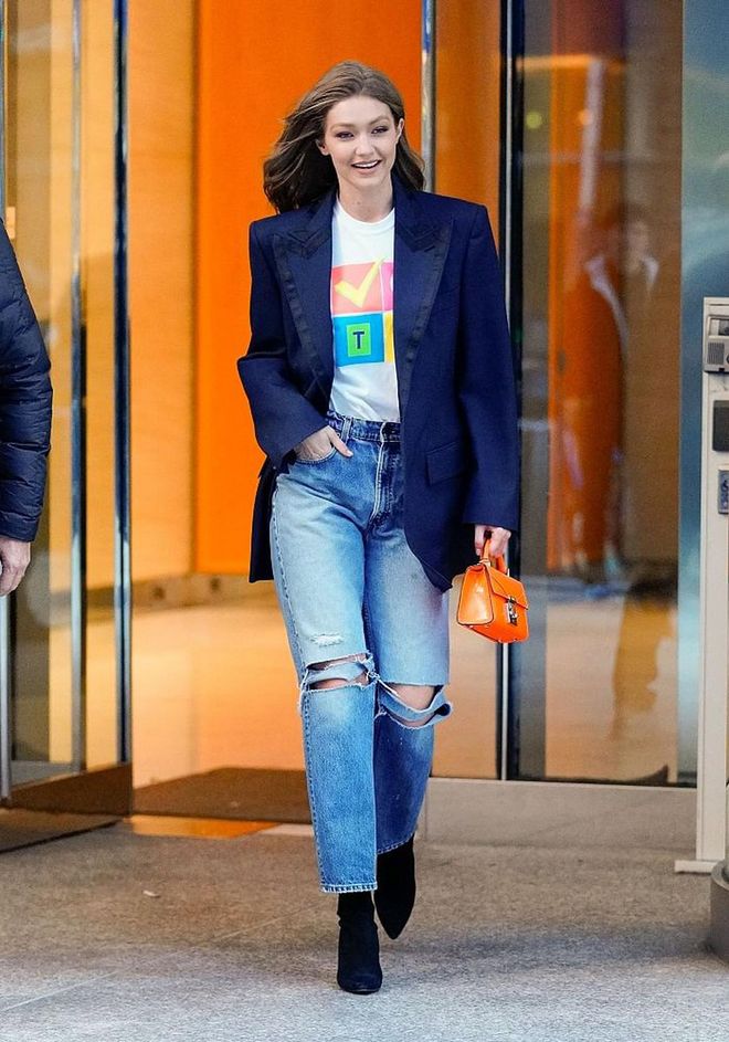 Gigi spotted wearing a Prabal Gurung T-shirt that says "Vote" in lieu of the elections with Danielle Guizio jeans and Stuart Weitzman black boots. She added a pop of colour with a neon orange Stalvey bag. 