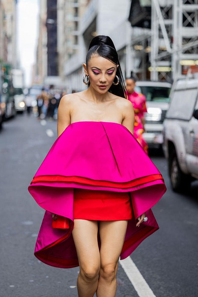 NEW YORK, NEW YORK - SEPTEMBER 12: Jessica Wang wearing pink off shoulder cape dress outside Carolina Herrera on September 12, 2022 in New York City. (Photo by Christian Vierig/Getty Images)