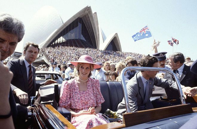 Driving through Sydney, Australia with Prince Charles in a floral pink dress and wide-brim hat. Photo: Getty
