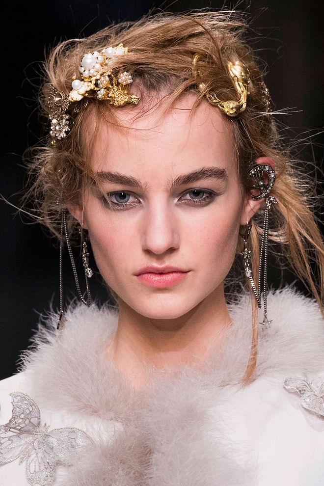 Guido described the hair at McQueen as having "a randomness and wrongness to it, which makes it punky. The clunkier it is, the better it is and the more you worry about it, the more wrong it looks." He used Redken Guts 10 to give messy, disheveled, thrown-up texture, then reached into a jewelry tray of brooches and chains and randomly decorated the updo with them.