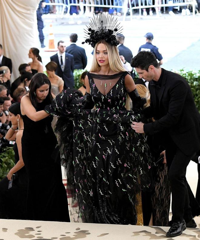 With that striking Prada gown, it takes a village to transport Rita from place to place. Photo: Getty 