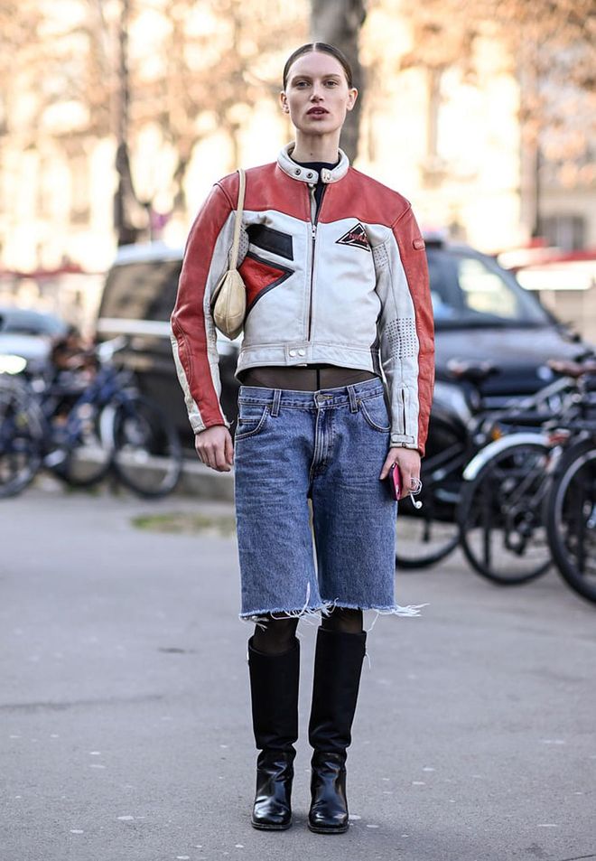 PARIS, FRANCE - MARCH 03: A model is seen wearing a biker jacket, jean shorts and black knee high boots with cream bag outside the Giambattista Valli show during Paris Fashion Week F/W 2023 on March 03, 2023 in Paris, France. (Photo by Daniel Zuchnik/Getty Images)
