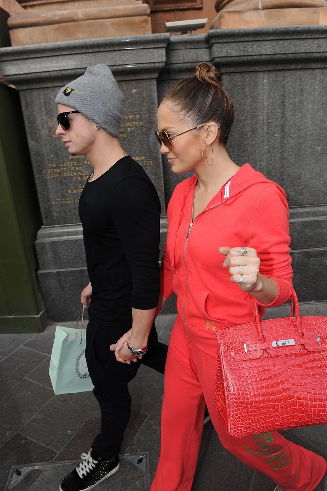 You can take the girl out from the Bronx, but you can't take the Bronx out of Jenny from the block. Dressed in a red tracksuit, the dancer/singer matches it with her Ferrari red Birkin and ex-boyfriend Casper Smart. Photo: Getty