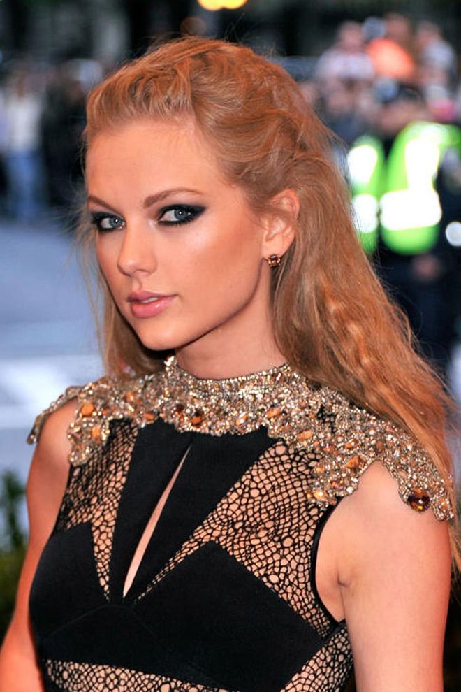 T-Swift knows just how to emphasize her bold eye makeup with this tousled twist on the traditional half up/half down hairstyle. Photo: Getty