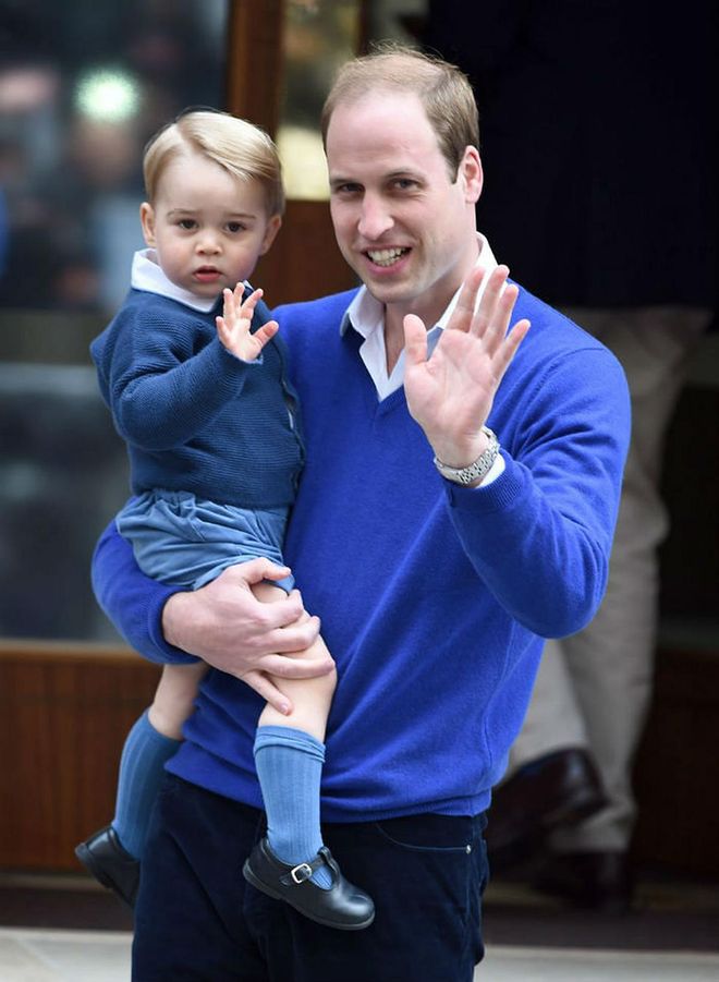 Sharing a royal father-son moment, Prince William and a then two-year-old Prince George wore similar blue sweaters and white collared shirts after the birth of Princess Charlotte. Photo: Getty