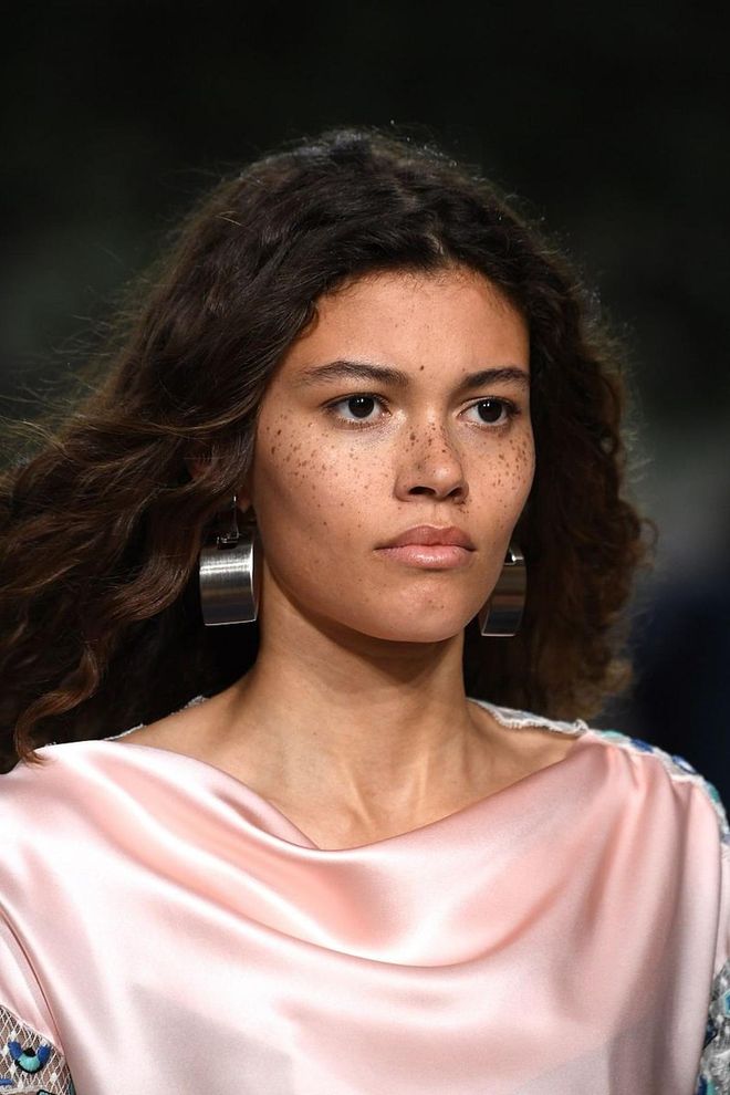 A freckled fantasy! Real skin is in for Louis Vuitton's show. Just a bit of brow powder for soft definition and a matte primer to smooth the skin's texture. Slather the lips with balm for a nourished look. Photo: Getty 