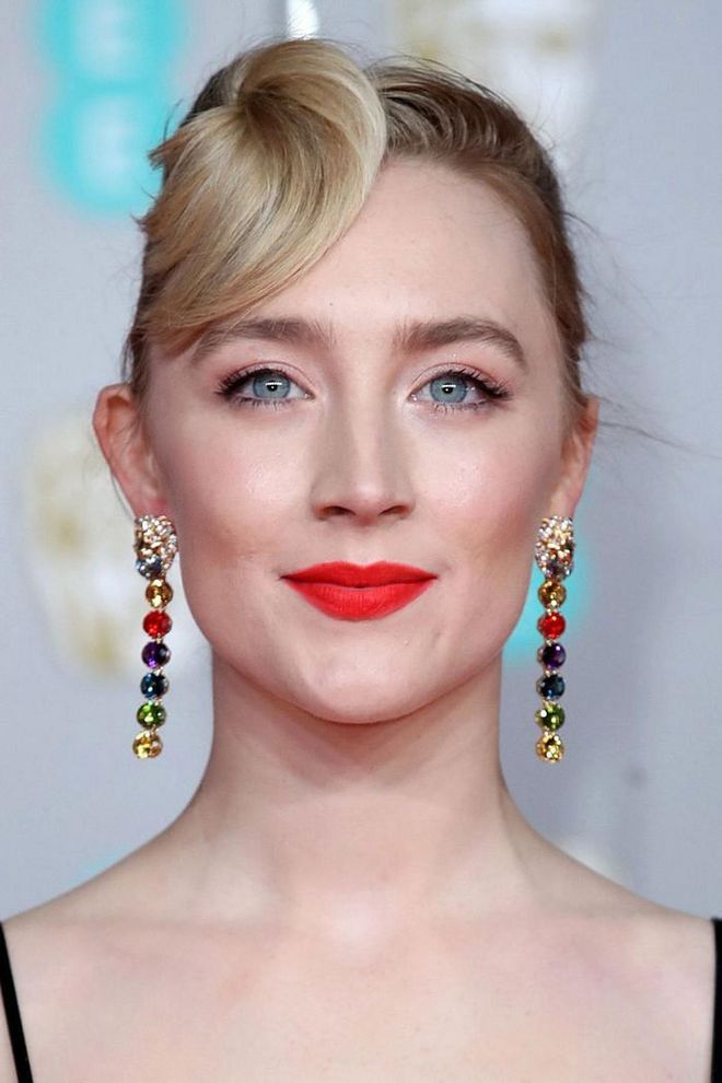 Saoirse Ronan added a playful touch to her bright red lipstick, with an unusually placed top-knot and rainbow earrings.

Photo: Mike Marsland