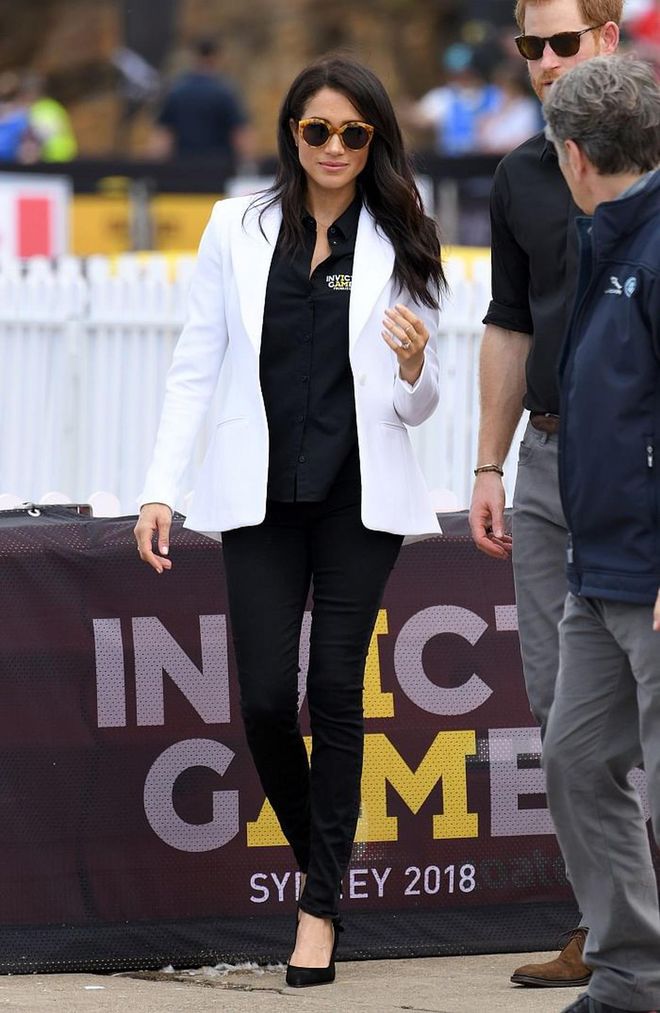 Meghan attends the Invictus Games Sydney 2018 Jaguar Land Rover Driving Challenge in a Altuzarra 'Acacia' white blazer over the official Invictus Games shirt. She also had on  ILLESTEVA 'Palm Beach' sunglasses for a touch of glam. 
