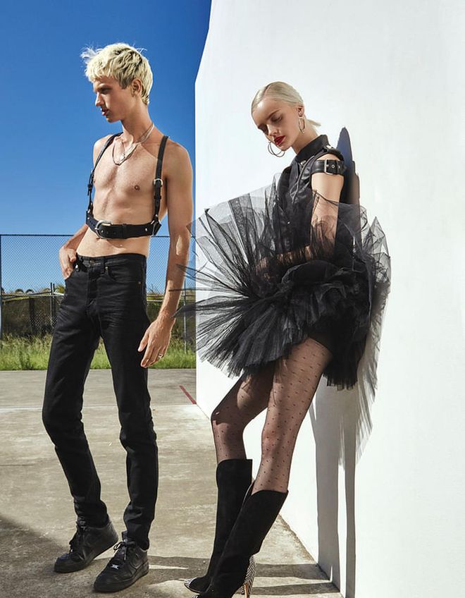 (On him) Leather harness, Zana Bayne at Net-a-Porter. Denim jeans, Saint Laurent by Anthony Vaccarello. Necklaces; ring; socks; sneakers, stylist’s own (all worn throughout). (On her) Leather vest; tulle skirt, Moschino. Metal earrings, Salvatore Ferragamo. Suede, leather and snakeskin boots, Givenchy. Stockings, stylist’s own