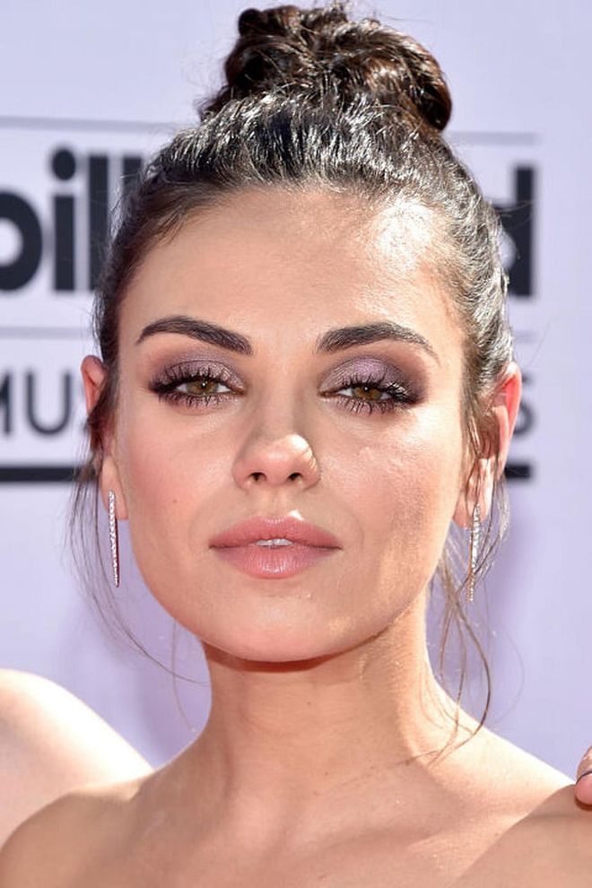 Mila Kunis' messy knot proves pristine hair is not a requirement for looking polished. Photo: Getty