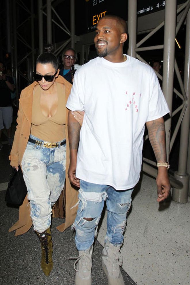 The couple dons matching airport style in coordinating distressed acid-wash jeans. Photo: Getty