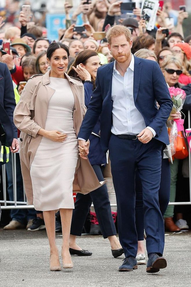 The Duchess of Sussex visited a charity for one of her public appearances, dressed in a white Brandon Maxwell midi dress, a classic Burberry trench and nude pumps. 
