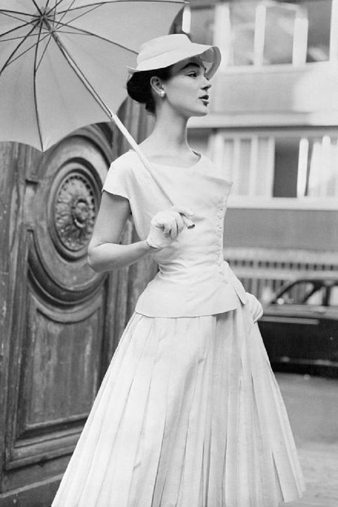 A woman models a summer dress and parasol.

Photo: Getty