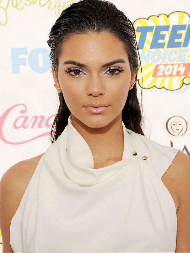 False lashes and a pop of white eyeshadow look cool against her tan skin.