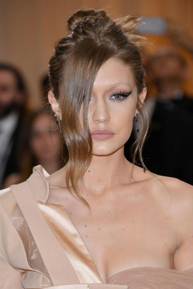 Hadid's newly dyed honey brown hair had a lock of curls covering one eye. The other boasted a well-defined wing tip that got heads turning on the red carpet (Photo: Getty)