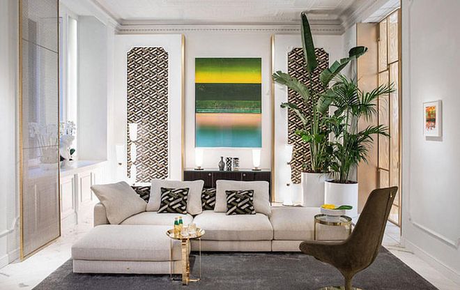 Pair the La Greca pattern with white for a subdued setting that makes the colourful artwork pop, like in this living room set up. (Photo: Versace)