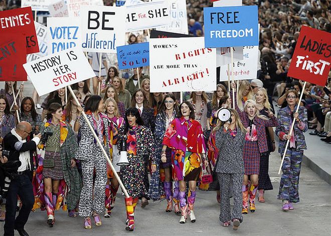 In 2014, the majestic Grand Palais in Paris was transformed into the fictional Boulevard Chanel, as models marched down the finale of the spring/summer 2015 runway en masse, carrying signs that read “Women’s rights are more than alright”.