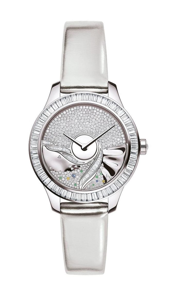 A one-of-a-kind white gold watch set with baguette, brilliant-cut, and rose-cut diamonds. The fascinating automatic movement gets its power from the oscillating weight decorated with diamonds, tsavorite garnets, sapphires, and yellow sapphires, which freely spin right on the dial. <b>Dior, Price Upon Request</b>
