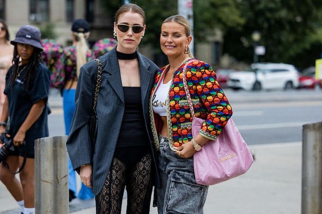 NEW YORK, NEW YORK - SEPTEMBER 11: Annabel Rosendahl wearing grey oversized striped blazer, laced black pants &amp; Janka Polliani wearing cropped top, denim jeans, colorful jacket, pink Chanel bag outside Ulla Johnson on September 11, 2022 in New York City. (Photo by Christian Vierig/Getty Images)