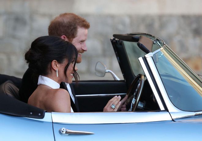 Prince Harry and Meghan Markle leave in a blue Jaguar
