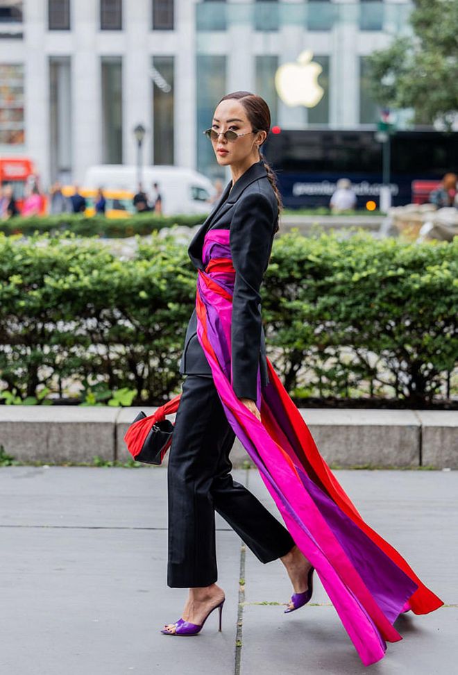 NEW YORK, NEW YORK - SEPTEMBER 13: Chriselle Lim is wearing a black suit with a pink scarf tied around her waist, matched with purple heels. (Photo by Christian Vierig/Getty Images)