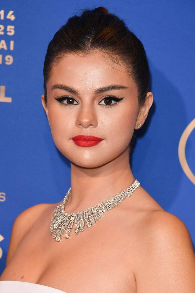 As Selena Gomez proves, classic cat eye liner and bold red lips make for the perfect party season pairing. Get the look with the L'Oreal Paris Flash Winged Eyeliner and MAC Lipstick in Russian Red. Photo: Getty