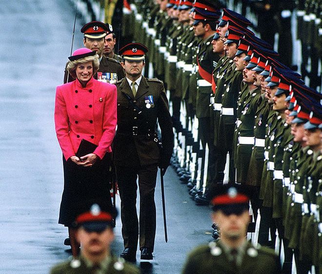 In a pink and black suit by Victor Edelstein and a hat by Frederick Fox while on a two-day visit to the Royal Hampshire Regiment in Berlin, Germany. Photo: Getty