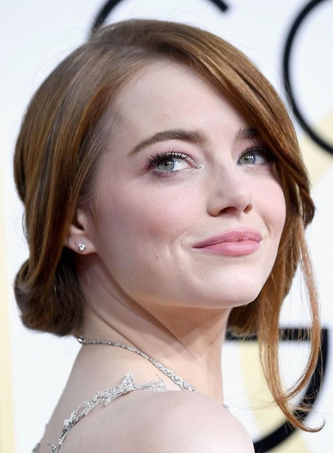 Emma Stone's rolled-up updo can easily be unpinned and let loose into voluminous waves for the wedding afterparty. Photo: Getty 