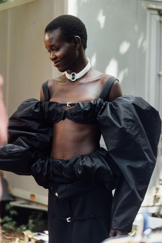 A model backstage at the Jacquemus fall 2023 show, wearing a similar Princess Diana-inspired necklace as Jenner.