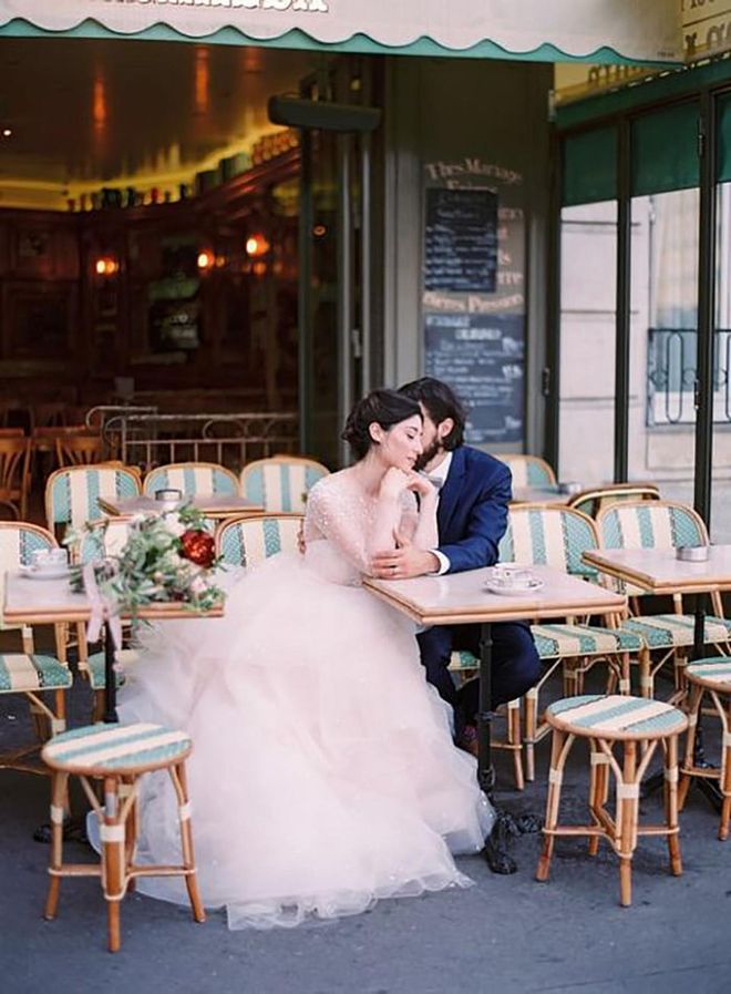 Nothing says Paris like a street lined with charming cafes. Here, a couple steals a moment amidst a sea of striped bistro chairs. C'est très romantique!

Via Le Secret d'Audrey

