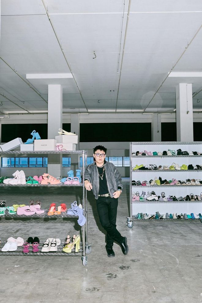 Joe Kean, a BAZAAR NewGen 2022 finalist on a six-month internship with CHARLES & KEITH. Here, he is pictured among the brand’s footwear