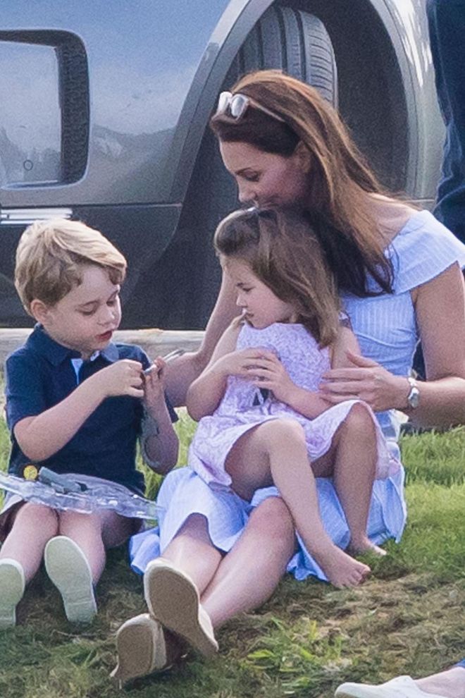 Not afraid to get down and dirty, the Duchess sits on the grass with Prince George and Princess Charlotte while attending a polo match at Beaufort Park.
Photo: Getty