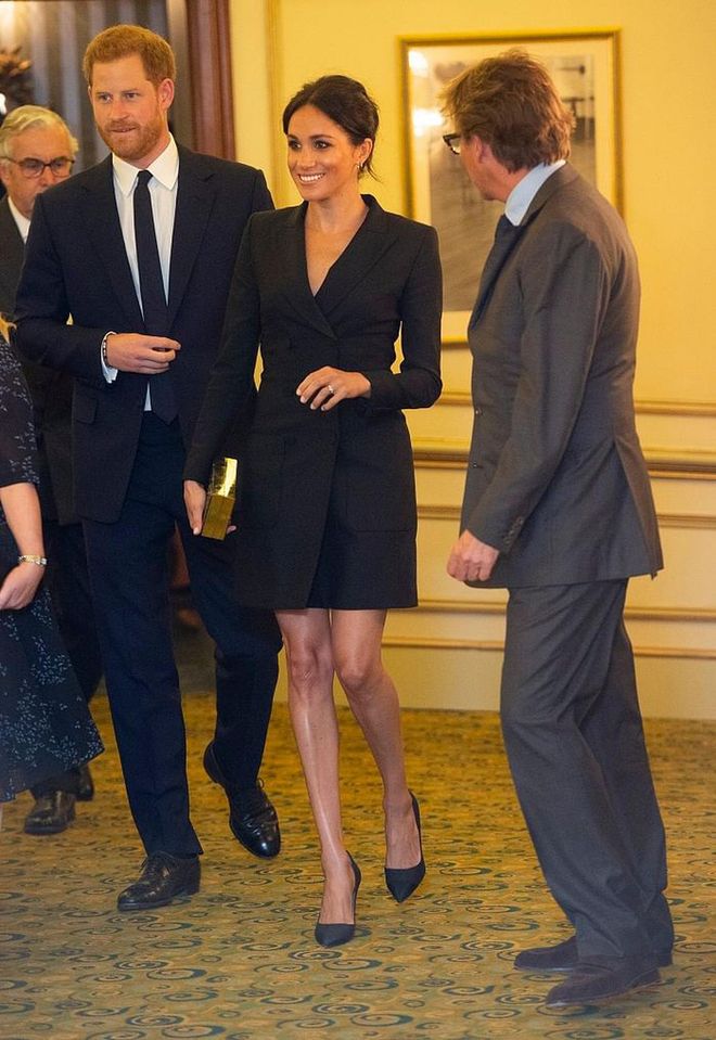 Meghan attended a gala performance of "Hamilton" at Victoria Palace Theatre in a black mini Tuexdo dress by Canadian designer, Judith & Charles.  She accessorized simple with a black and gold Jimmy Choo box clutch and black pumps by Paul Andrew. 