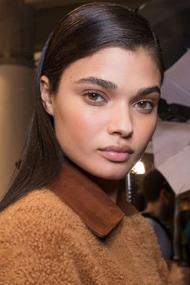 Hair was straight, sleek, and tucked behind the ears backstage at Laroche.
