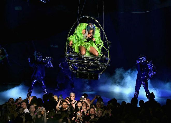 A quick costume change saw Lady Gaga don a fluorescent green, epically feathered jacket, as she was suspended from the ceiling in a cage.