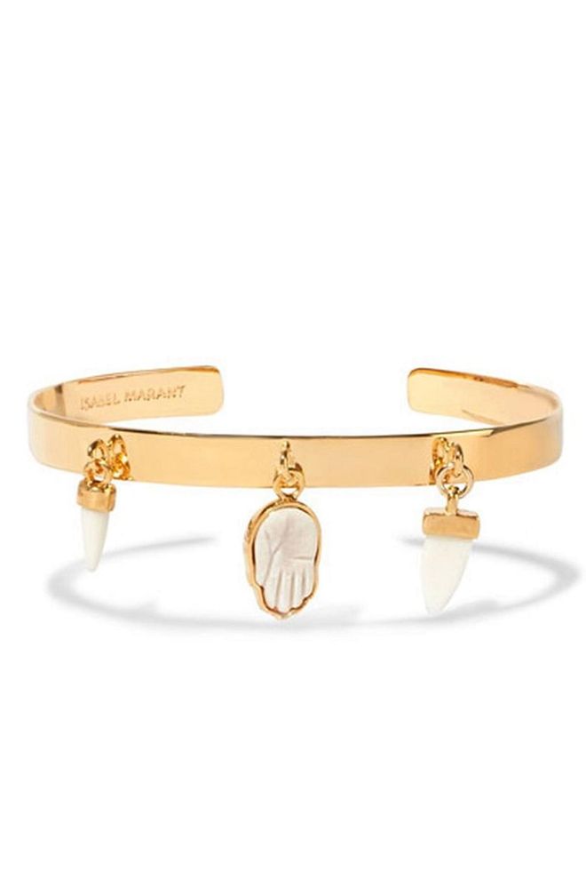 Embellished with Hamsa and tusk charms expertly carved from bone, this Isabel Marant bangle is a boho-lover's dream.