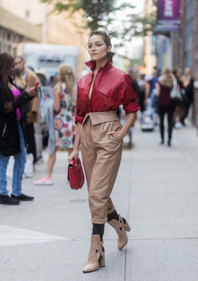 Olivia Culpo at New York Fashion Week, outside the Zadig &amp; Voltaire show, wearing red Tods button shirt, beige pants, glasses and boots Tods.
Photo: Getty