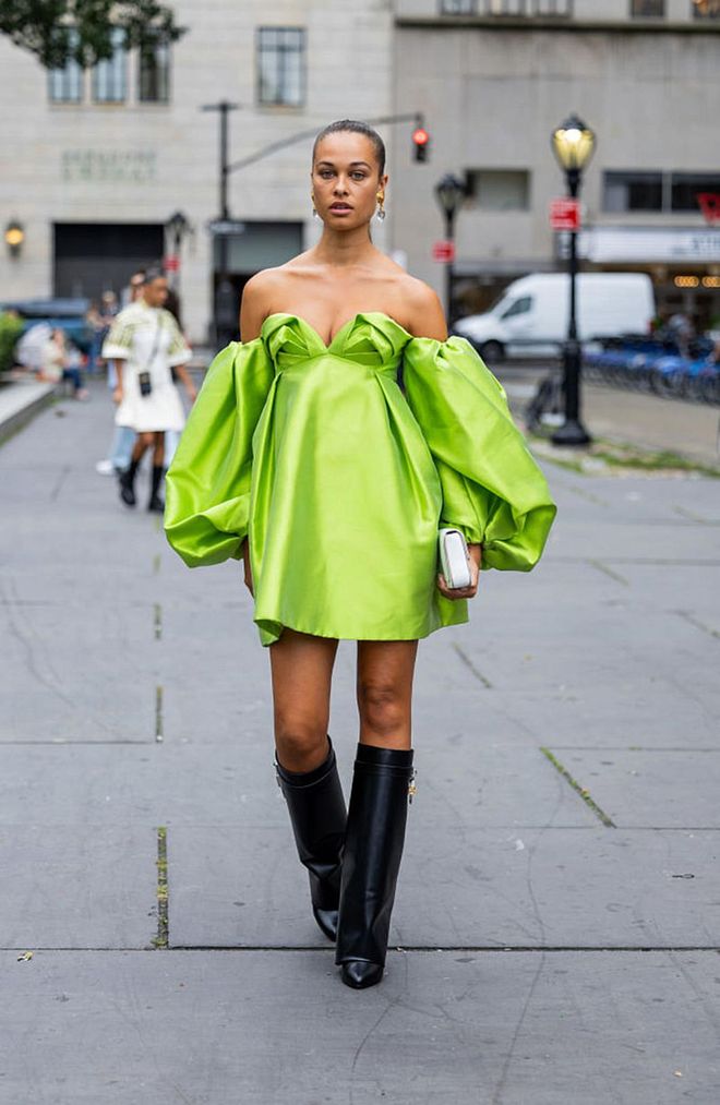 NEW YORK, NEW YORK - SEPTEMBER 14: Sarah Lysander wearing a neon green off-shoulder puffy short dress with knee high boots and a white clutch bag. (Photo by Christian Vierig/Getty Images)